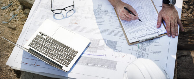 Contractors reviewing construction documents and permits on-site.